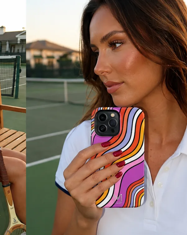 Woman on a tennis court at golden hour holding a Miarobi designer iPhone case in a retro rainbow wave print — aesthetic tennis-core phone case for iPhone 15, iPhone 14 and Samsung Galaxy
